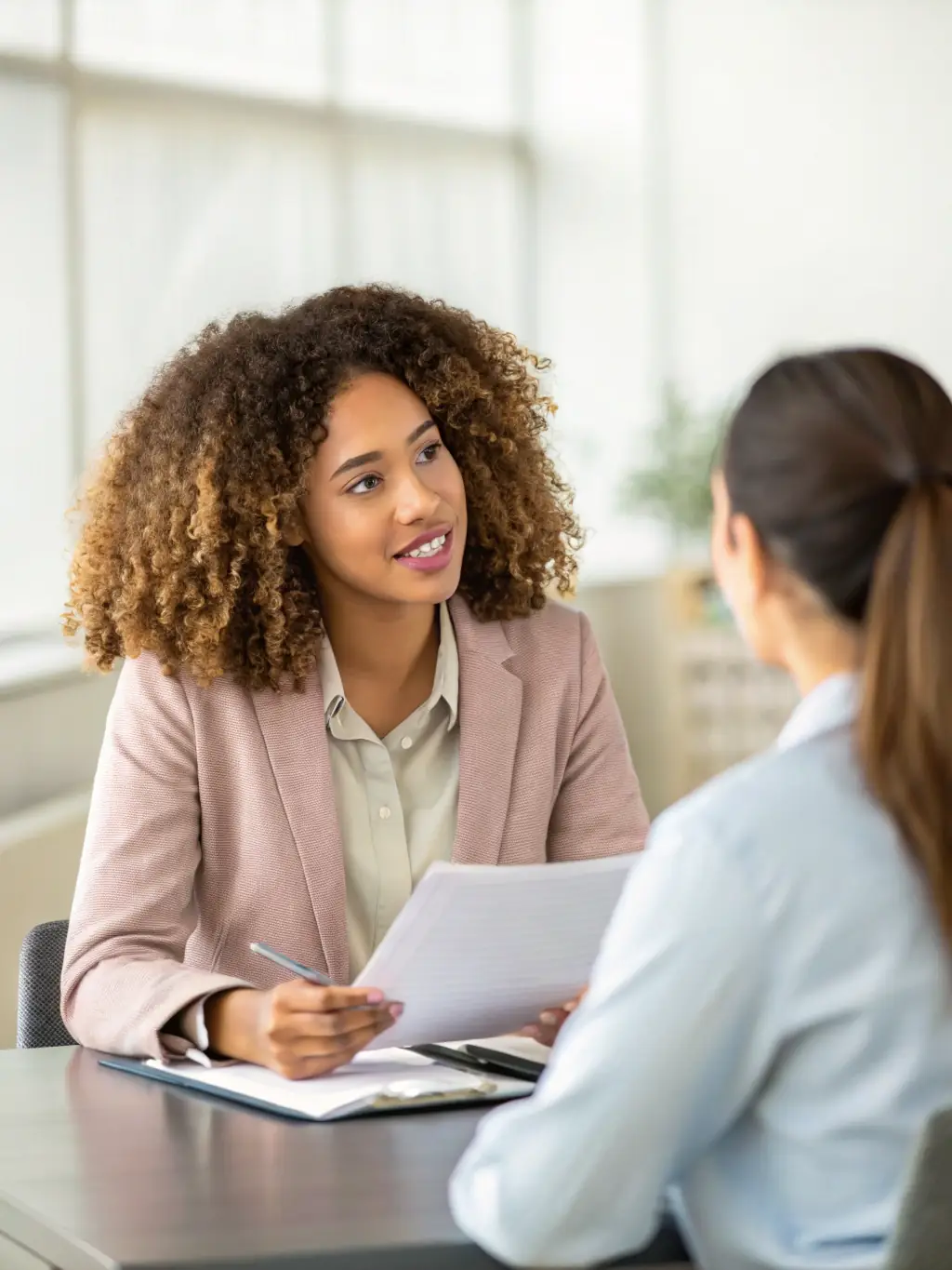 A person participating in a mock interview, receiving feedback from an interviewer, highlighting the soft skills coaching aspect of the program.